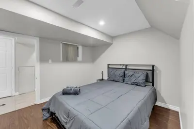 a bedroom with a large bed in a white room at Spacious 6BR Getaway Sleeps 16 Yard and Parking in Brampton