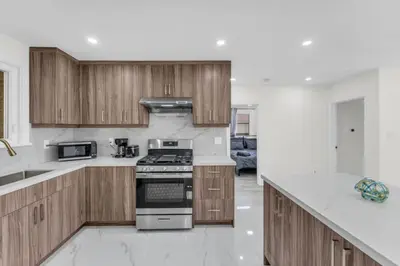 a kitchen with wooden cabinets and a stove top oven at Spacious 6BR Getaway Sleeps 16 Yard and Parking in Brampton