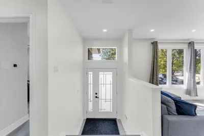 a hallway leading to a living room with white walls at Spacious 6BR Getaway Sleeps 16 Yard and Parking in Brampton