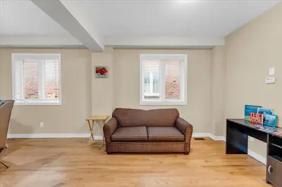 a living room with a couch and two windows at Bright and Stylish Family Home Near Niagara Falls in Thorold