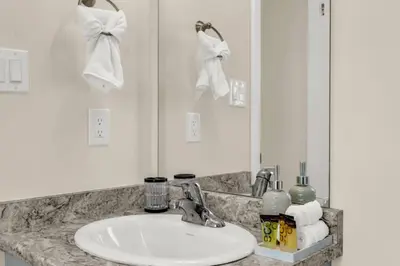 a bathroom counter with a sink and a mirror at Stylish Niagara Falls Getaway with Rooftop City Views in Niagara Falls