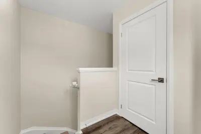 an open white door in a white room with wooden floors at Stylish Niagara Falls Getaway with Rooftop City Views in Niagara Falls