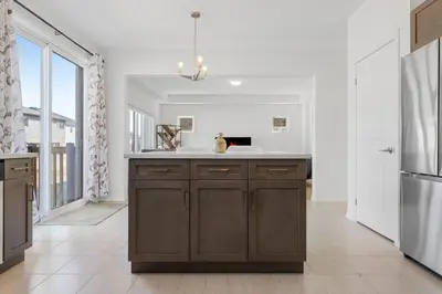 a kitchen with brown cabinets and a large window at Luxury New Home By Niagara Fall in Fonthill