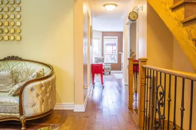 a living room with a couch and a clock on the wall at Royal Luxury Central Home with Gazebo By Toronto in Brampton