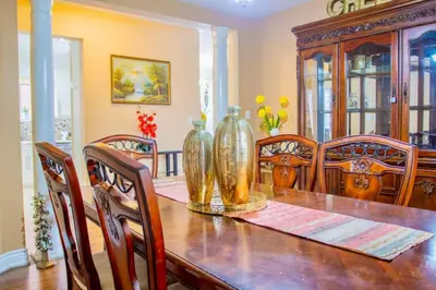 a dining room with a wooden table with vases on it at Royal Luxury Central Home with Gazebo By Toronto in Brampton