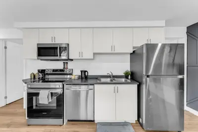 a kitchen with white cabinets and stainless steel appliances at New 2BD Townhouse Mins from Niagara Falls in Niagara Falls