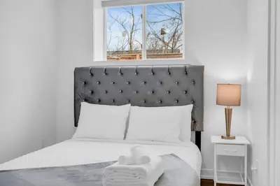 a bedroom with a bed with a headboard and a window at New 2BD Townhouse Mins from Niagara Falls in Niagara Falls