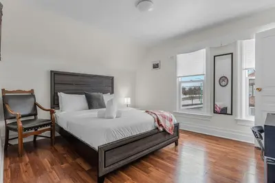 a bedroom with a bed and a chair at Cozy Home Short Walk to Falls Nintendo FirePit in Niagara Falls
