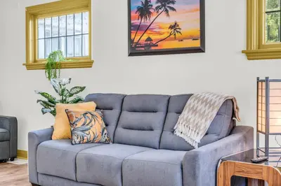 a blue couch in a living room with a table at Cozy Home Short Walk to Falls Nintendo FirePit in Niagara Falls