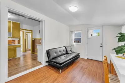 a black leather couch sitting in a living room at Cozy Home Short Walk to Falls Nintendo FirePit in Niagara Falls