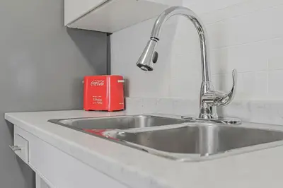 a kitchen counter with a sink and a red book at Cozy Home Short Walk to Falls Nintendo FirePit in Niagara Falls