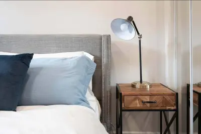 a lamp on a night stand next to a bed at Casa Hotel Stylish Modern Family Suite with Patio in Toronto