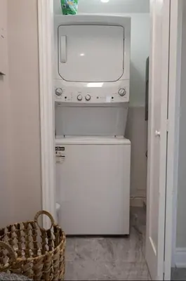 a small white washer and dryer in a room at Casa Hotel Stylish Modern Family Suite with Patio in Toronto