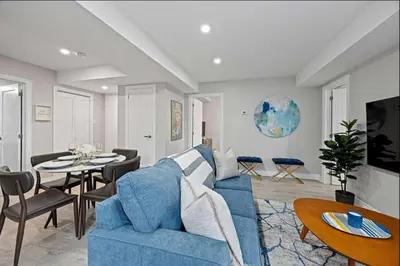 a living room with a blue couch and a table at Casa Hotel Stylish Modern Family Suite with Patio in Toronto