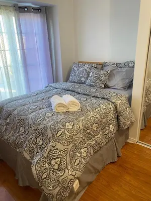 a bedroom with a bed with two towels on it at The cozy crest in Brampton