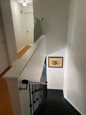 a stairway with a white wall and a stair case at The cozy crest in Brampton