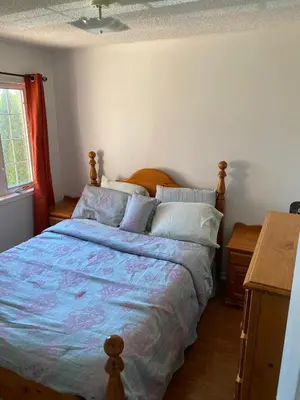 a bedroom with a bed with a blue comforter at The cozy crest in Brampton