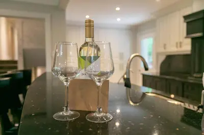 two wine glasses sitting on a counter in a kitchen at Luxury 4BR Stay with Swim Spa, Golf and Fireplaces in Caledon
