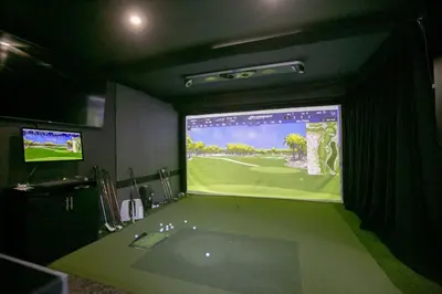 a bathroom with a large screen showing a golf game at Luxury 4BR Stay with Swim Spa, Golf and Fireplaces in Caledon