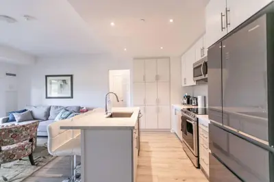 a kitchen and living room with a couch in the background at Modern 2BR Getaway with Balcony, BBQ and Parking in Innisfil