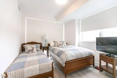 a bedroom with two beds and a flat screen tv at Modern 2BR Getaway with Balcony, BBQ and Parking in Innisfil