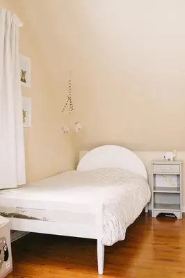 a white bed in a bedroom with a white curtain at Wellington Waterfront Home in Wellington