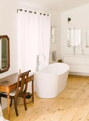a large white bath tub in a bathroom with a wooden table at Wellington Waterfront Home in Wellington