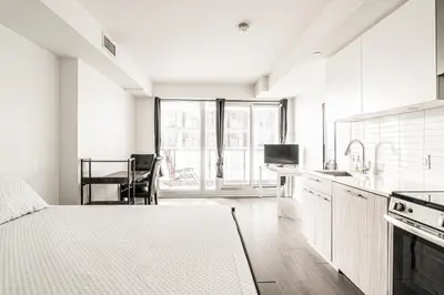 a white kitchen with a bed and a table at Toronto Downtown Elite Residence - Available for Christmas in Toronto