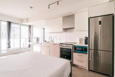 a kitchen with white cabinets and a stainless steel refrigerator at Toronto Downtown Elite Residence - Available for Christmas in Toronto