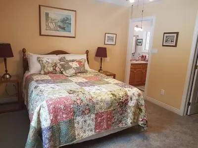 a bedroom with a bed with a quilt on it at White Rolling Sands of Penetang by Theatre in Penetanguishene