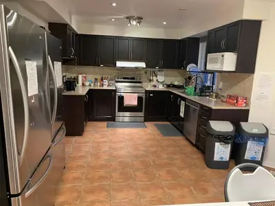 a kitchen with black cabinets and stainless steel appliances at VP1 master bedroom on second floor in Mississauga