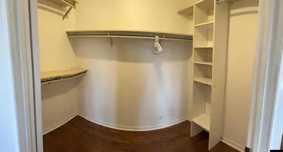 a walk in closet with white walls and wooden floors at VP1 master bedroom on second floor in Mississauga