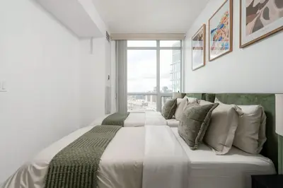 a large white bed in a room with a window at Stunning 1BD Lakeview Condo near BMO Free Parking in Toronto