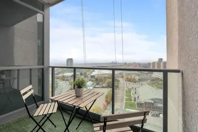 a balcony with a table and chairs and a view of a city at Stunning 1BD Lakeview Condo near BMO Free Parking in Toronto