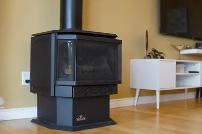 a black stove sitting in a living room at Lake-Access Cottage- Hot Tub, Fireplace&Pool Table in Bewdley