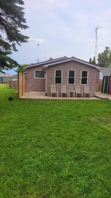 a mobile home with chairs on a lawn at Lake-Access Cottage- Hot Tub, Fireplace&Pool Table in Bewdley