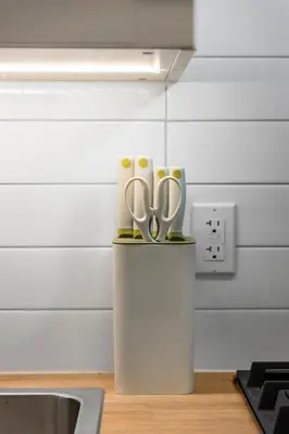 a container with scissors on a counter in a kitchen at High Park Grove Modern 1B1B, Kitchen, Laundry in Toronto