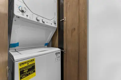 a white stove top oven sitting next to a refrigerator at High Park Grove Modern 1B1B, Kitchen, Laundry in Toronto