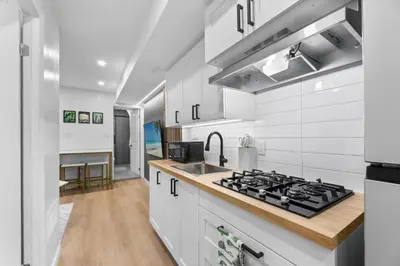 a kitchen with a stove and a sink at High Park Grove Modern 1B1B, Kitchen, Laundry in Toronto