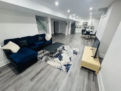 a living room with a blue couch and a table at Hearth & Home Spacious Suite in Pickering