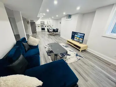 a living room with a blue couch and a table at Hearth & Home Spacious Suite in Pickering