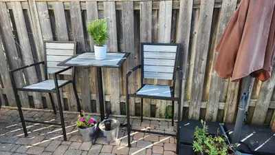 two chairs and a table with plants on it next to a fence at Togather Time,5 minutes to HYW 401 in Oshawa