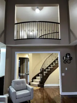 a living room with a staircase and a chair at 3300 SqFt - Modern and Comfort - 3 BDRM Getaway - Relax - Unwind - Explore - Near Toronto Pearson Airport & Toronto Downtown in Brampton