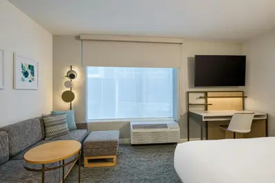 a living room with a couch and a tv at TownePlace Suites by Marriott Woodstock in Woodstock