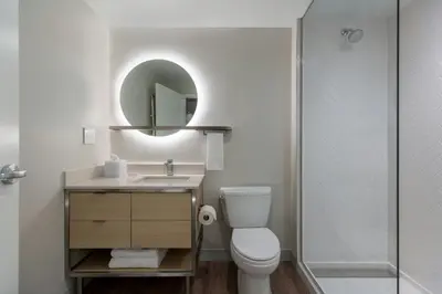 a bathroom with a toilet and a sink and a shower at TownePlace Suites by Marriott Woodstock in Woodstock
