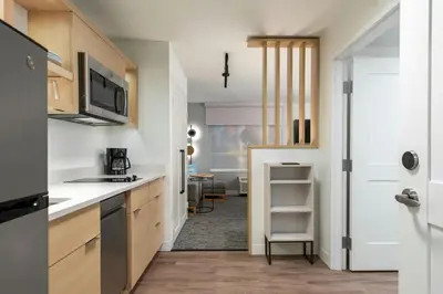a kitchen with white countertops and a door to a room at TownePlace Suites by Marriott Woodstock in Woodstock