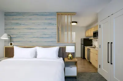 a bedroom with a bed and a kitchen at TownePlace Suites by Marriott Woodstock in Woodstock