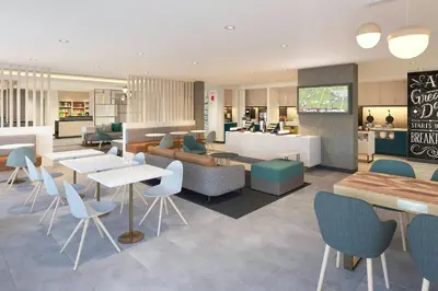 a restaurant with tables and chairs in a cafeteria at TownePlace Suites by Marriott Woodstock in Woodstock