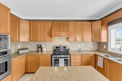 a kitchen with wooden cabinets and a stove top oven at Luxury Mansion by Toronto and YYZ with Large Backyard Weddings in Brampton