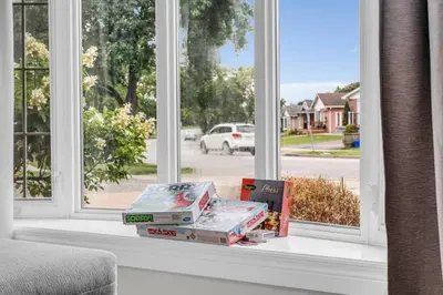 a pile of books sitting on a window sill at Bright 6BR Near Niagara Falls with BBQ Yard in Thorold